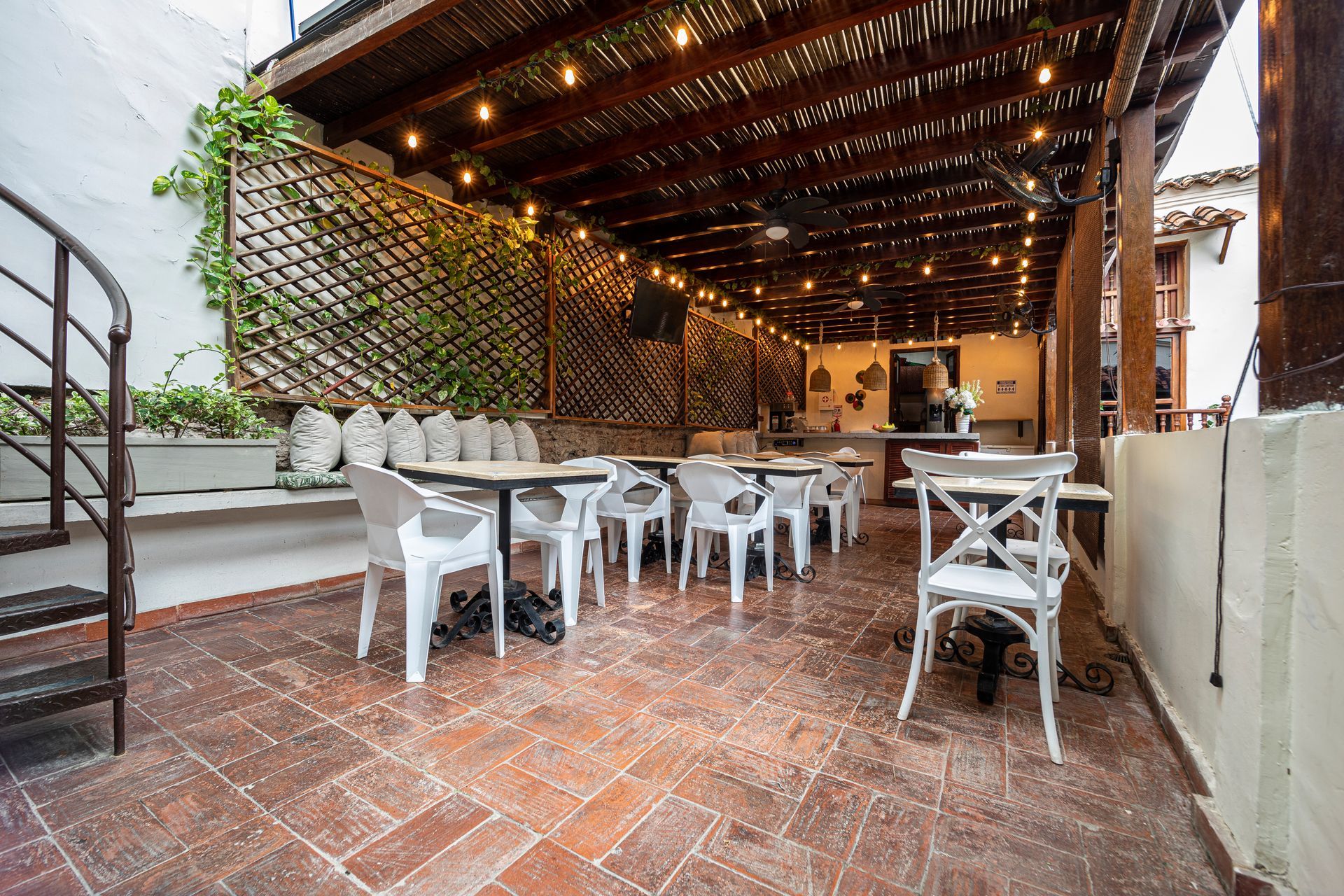 A patio with tables and chairs and a spiral staircase.