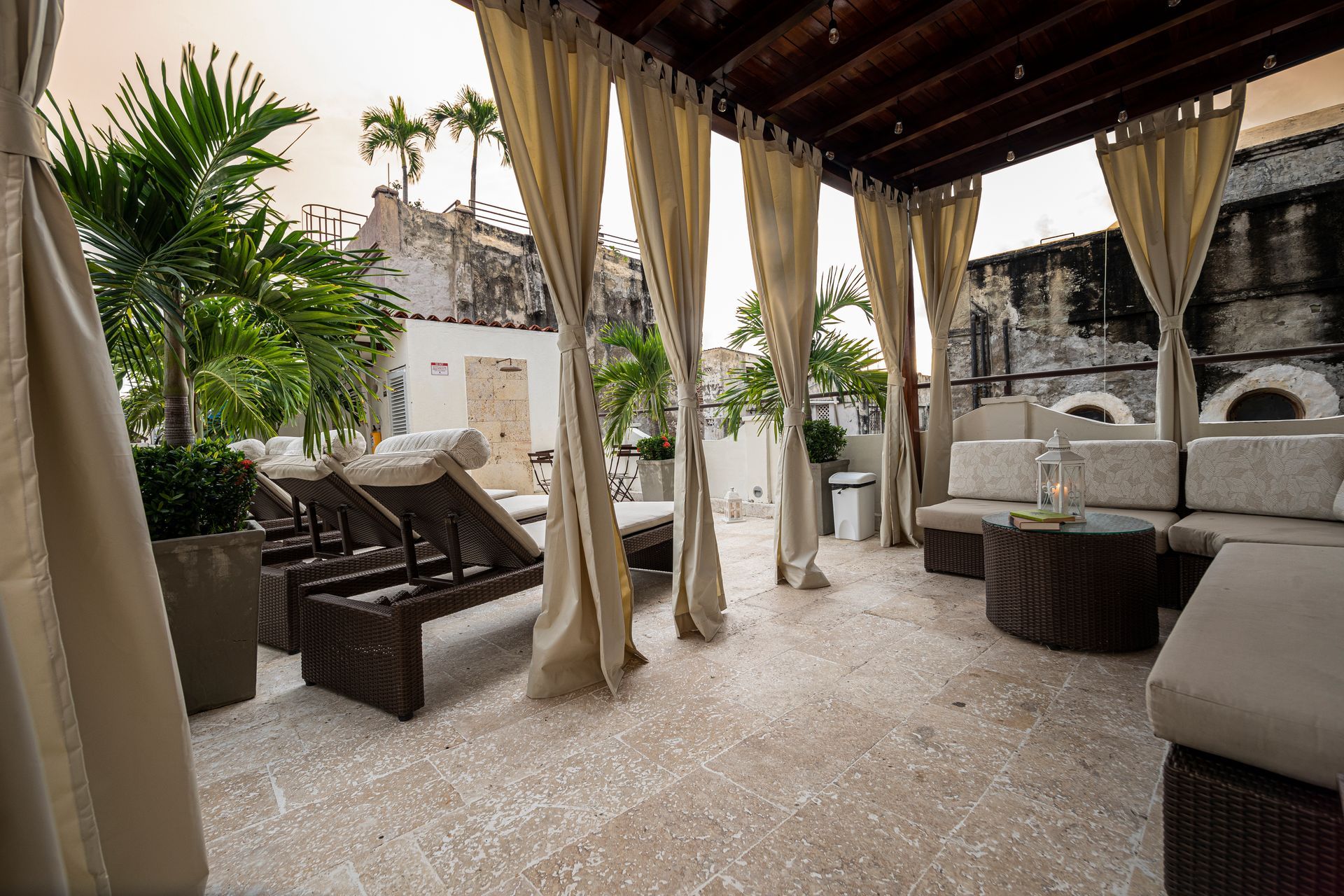A patio with a couch and chairs under a canopy.