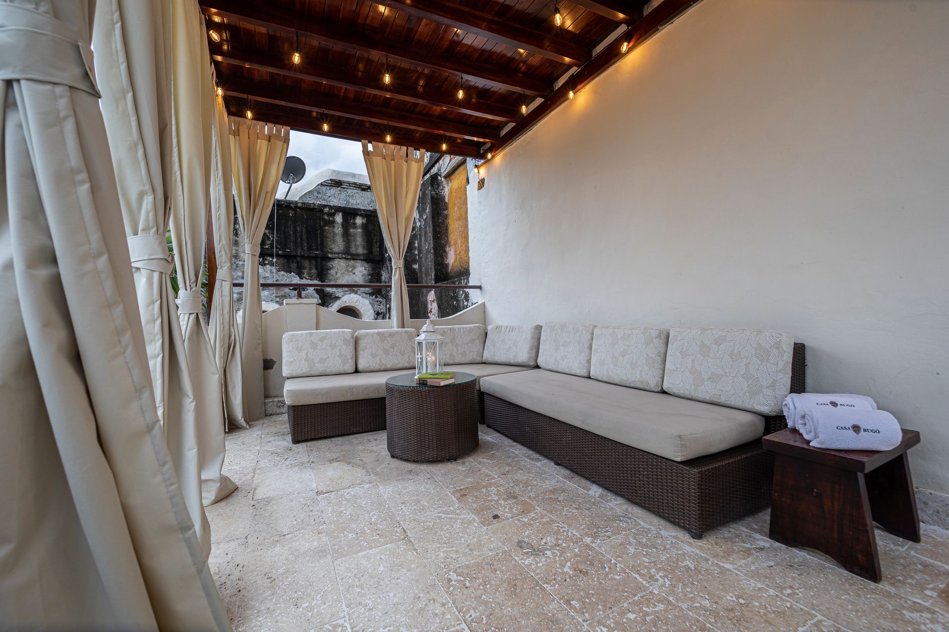 A patio with a couch and a table under a canopy.