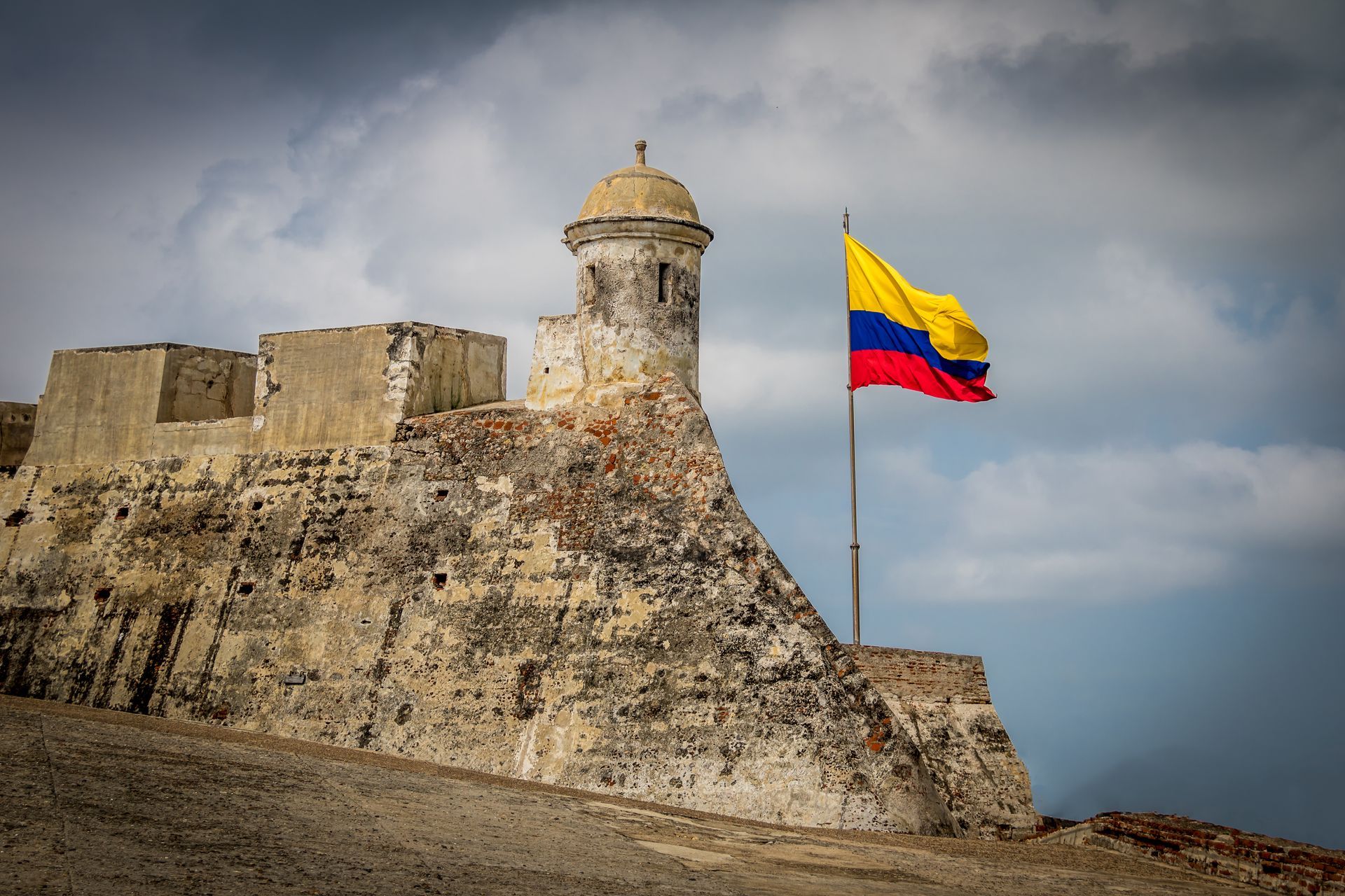 A castle with a colombian flag flying in front of it.