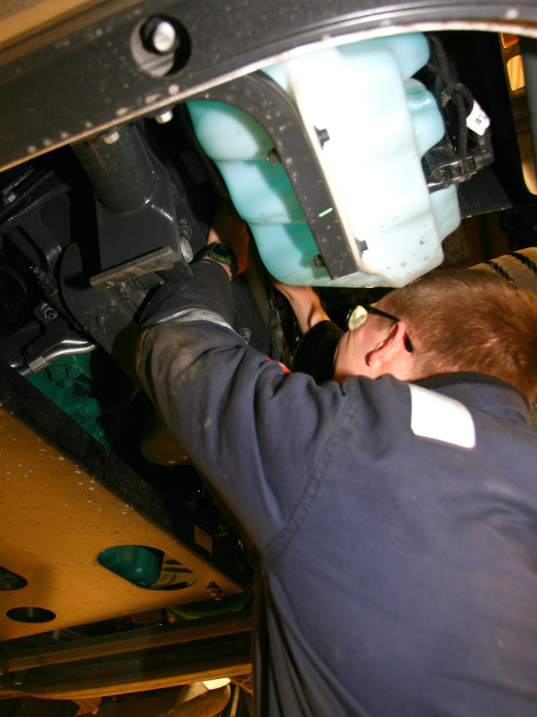 A workman connecting a large hose to a tanker