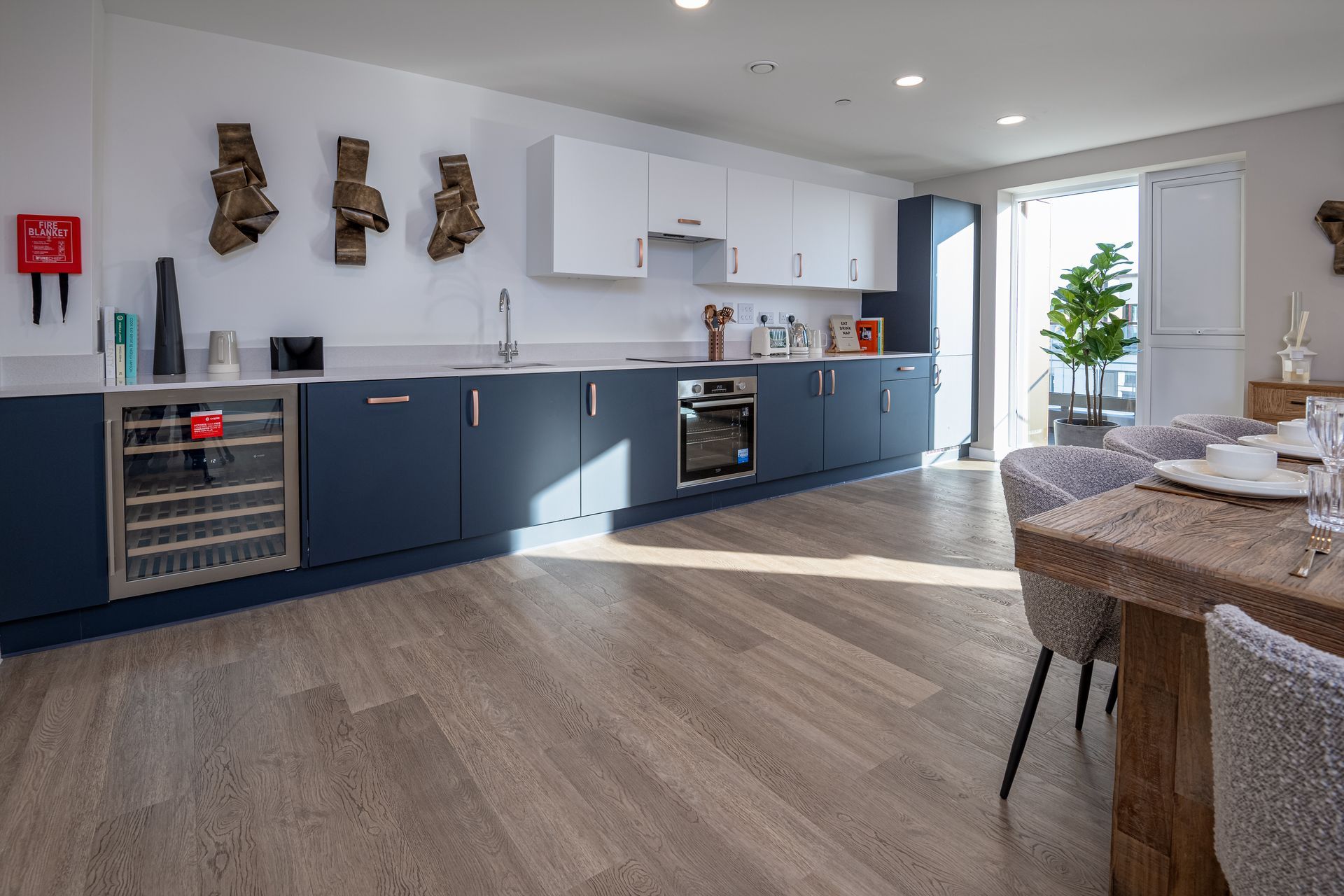 A kitchen with blue cabinets and a wooden table and chairs at Walton Court.