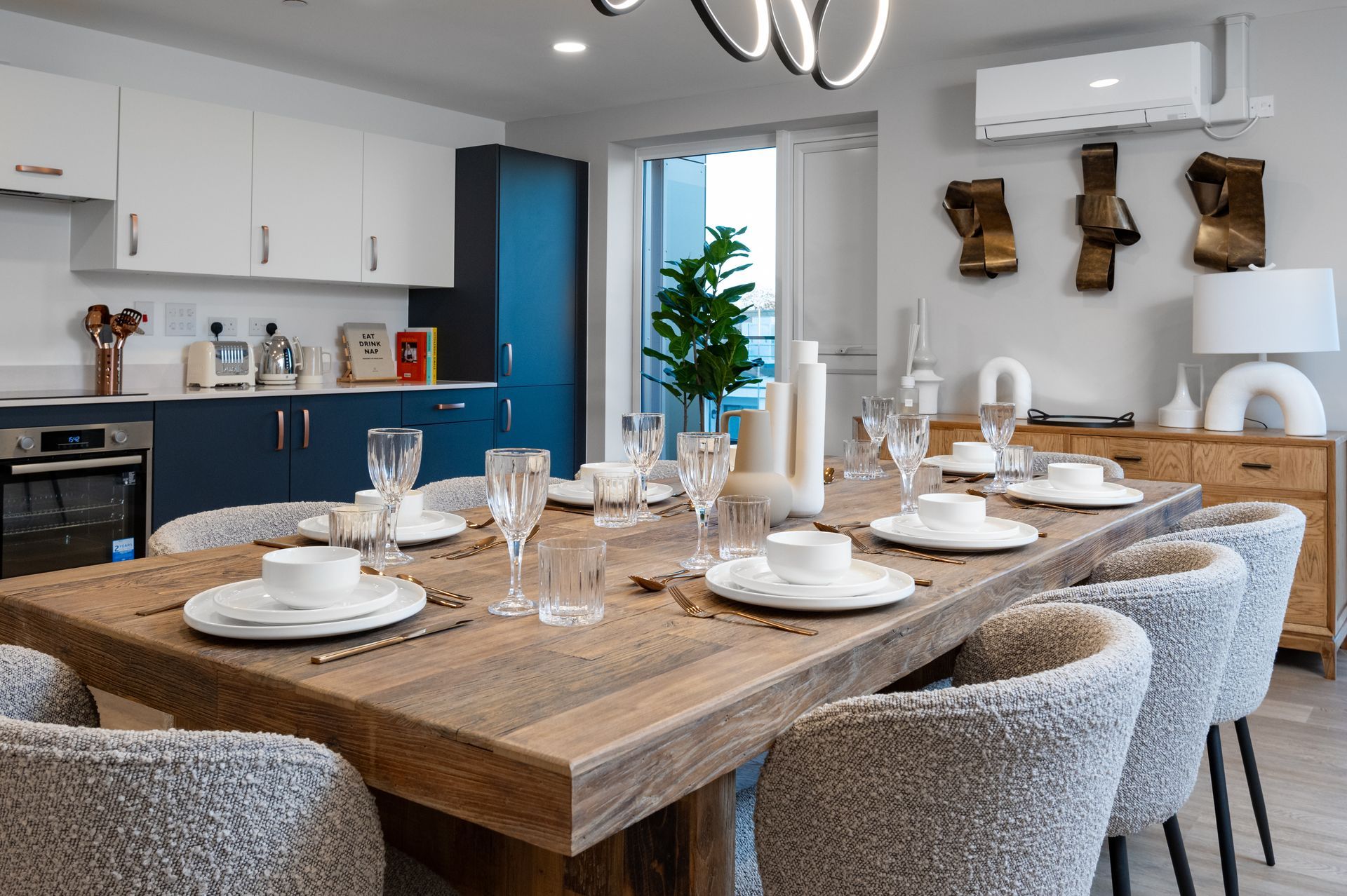 A dining room with a long wooden table and chairs at Walton Court.