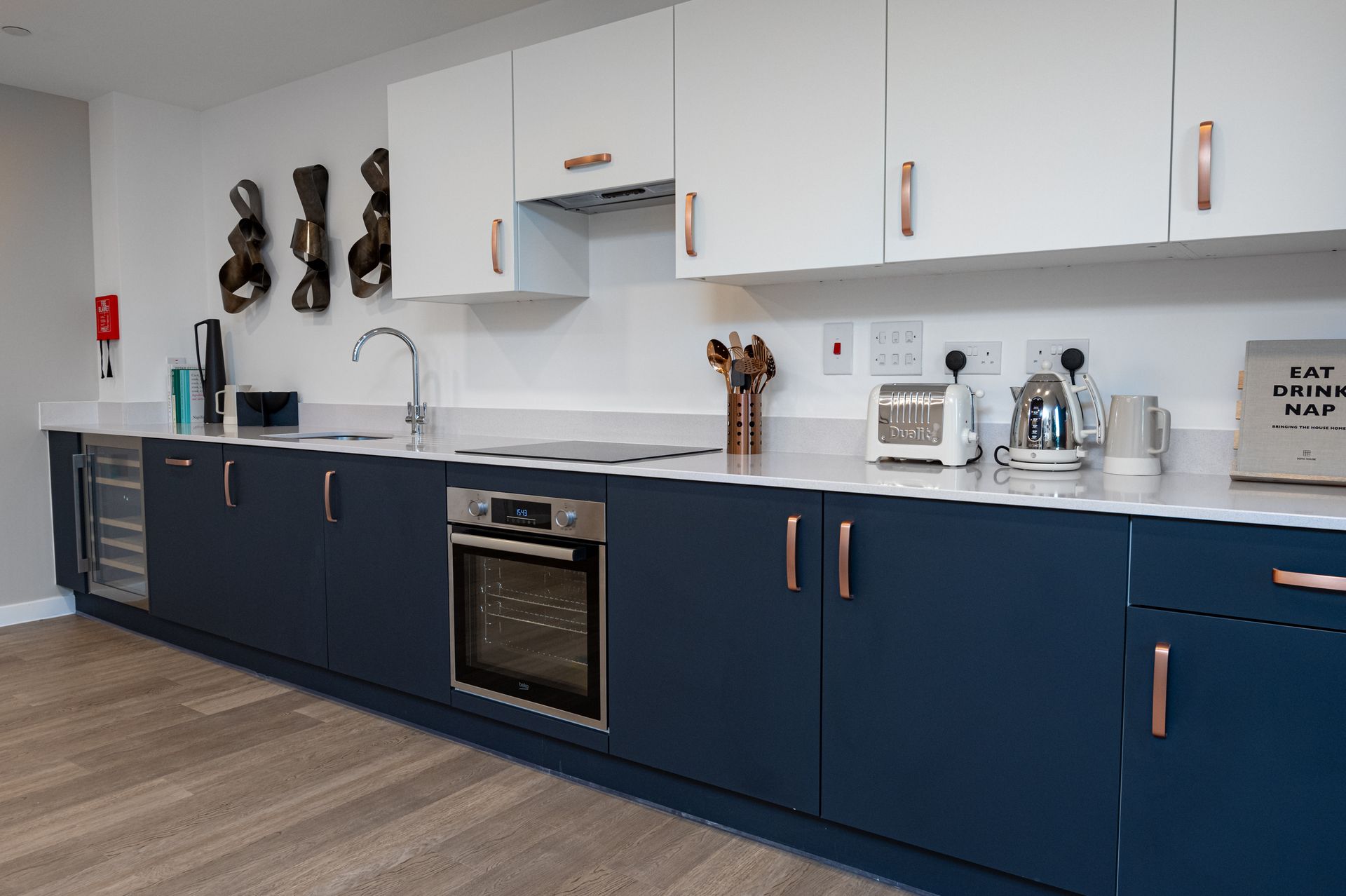 A kitchen with blue cabinets and white counter tops at Walton Court.