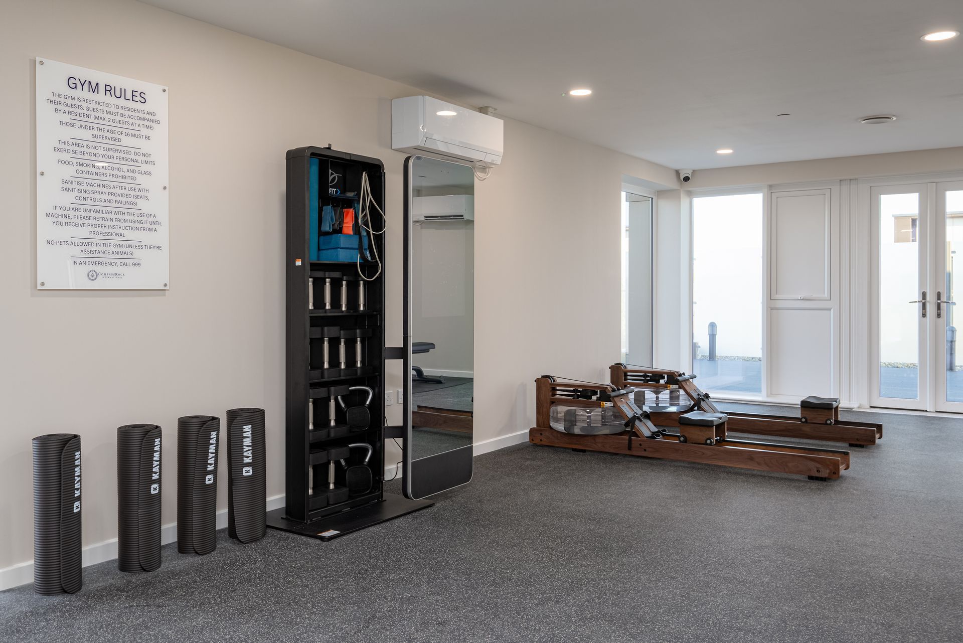 A large room with a lot of exercise equipment and a large mirror at Walton Court.