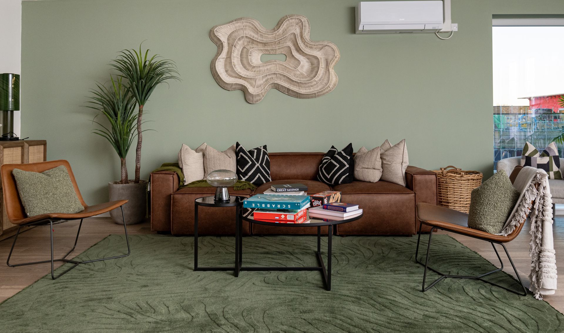 A living room with a brown couch , chairs , a coffee table and a green rug at Walton Court.