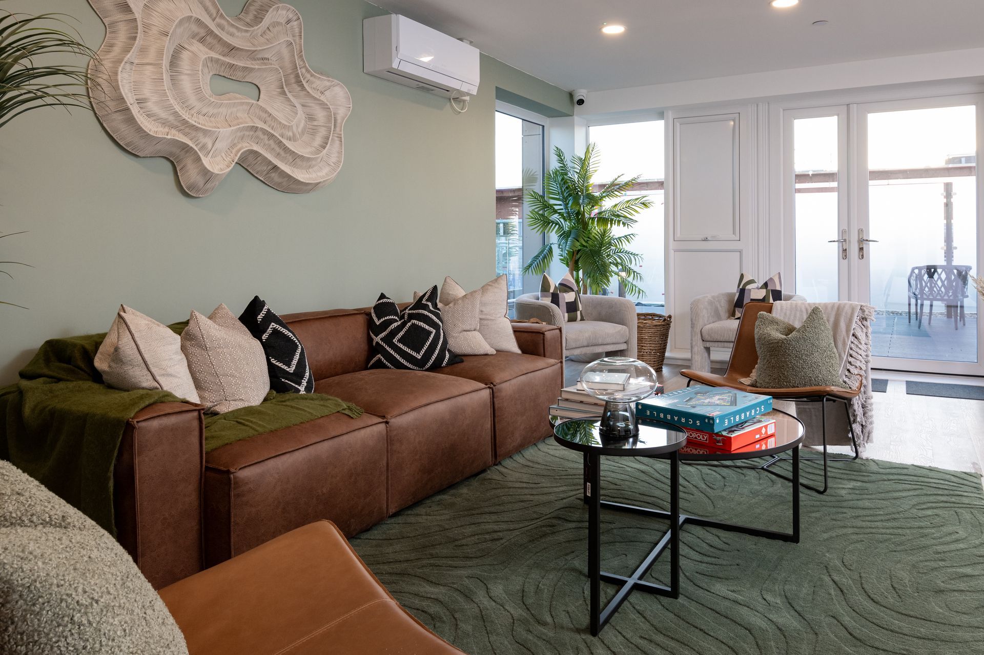 A living room with a brown couch , chairs , and a coffee table at Walton Court.