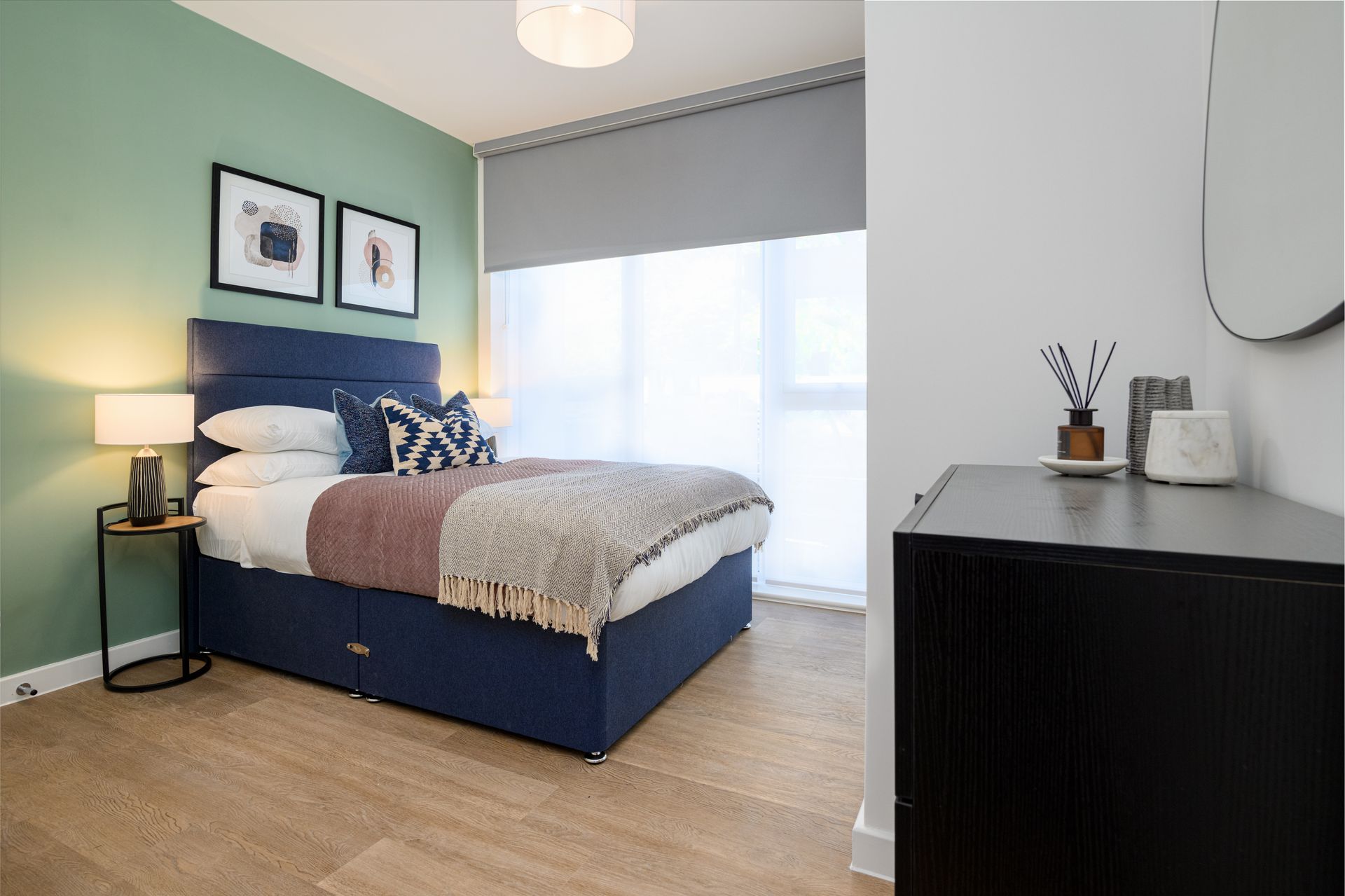 A bedroom with a bed , nightstand , mirror and dresser at Walton Court.