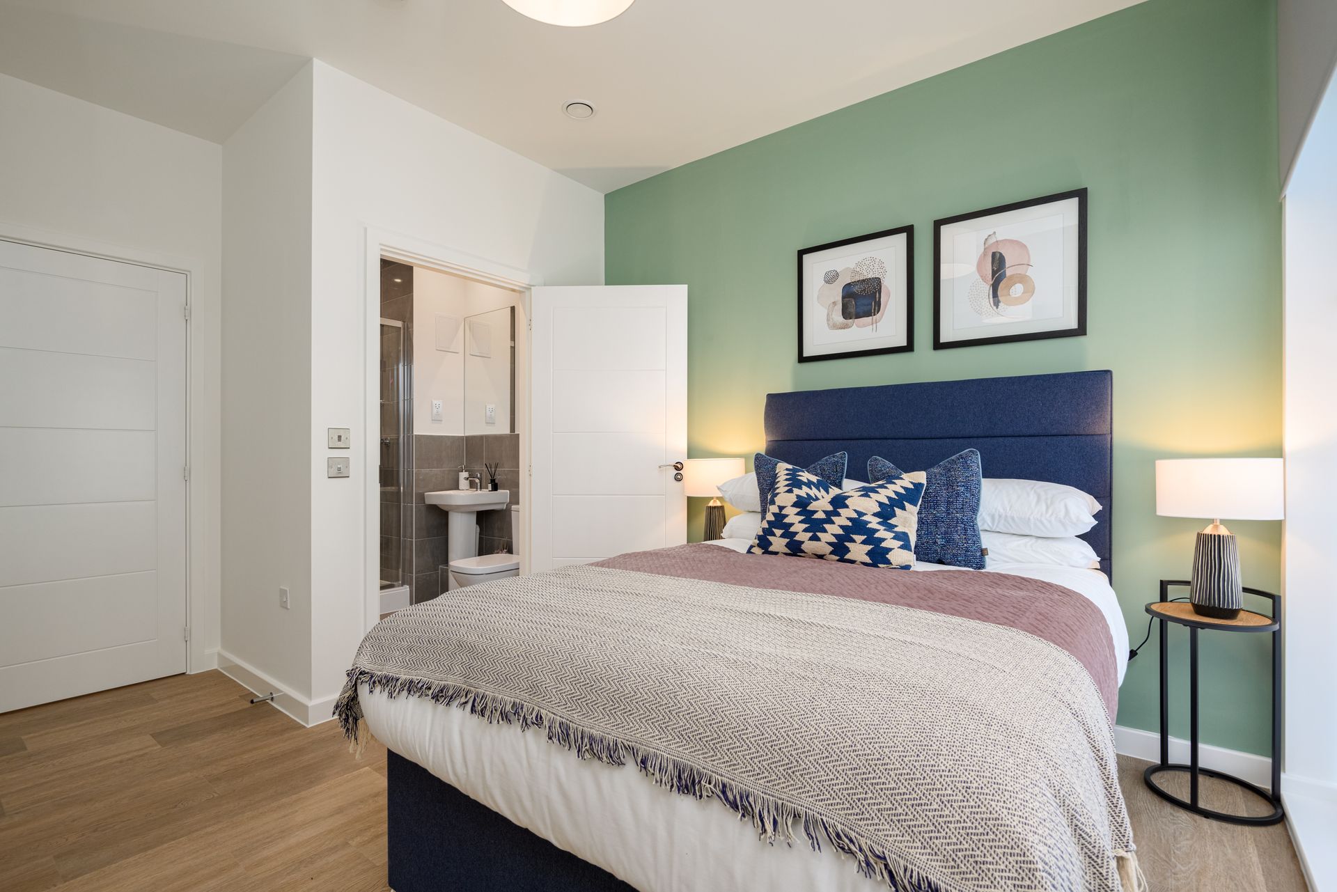 A bedroom with a bed , lamps , and a bathroom at Walton Court.