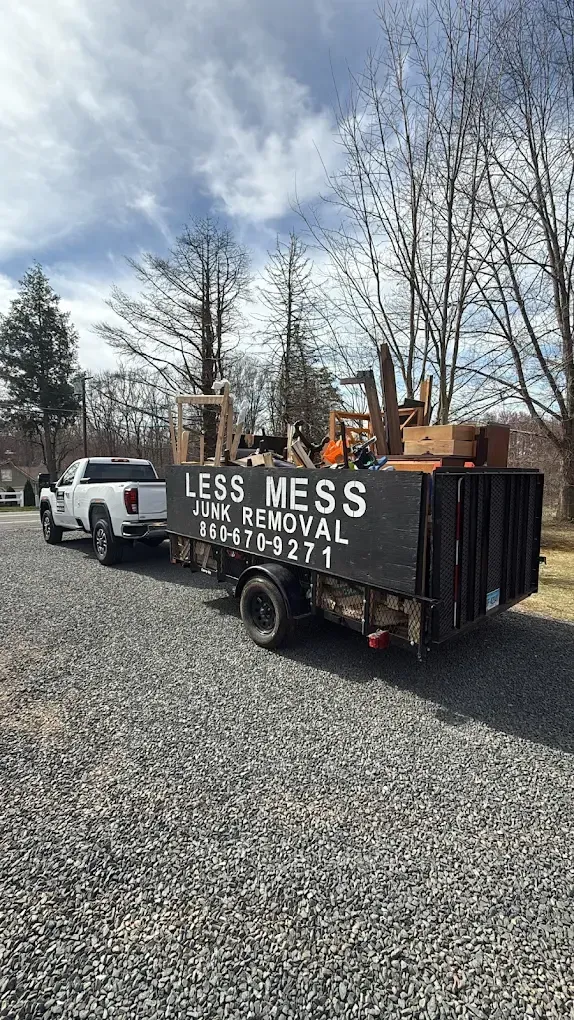 A white pickup truck towing a black trailer labeled 
