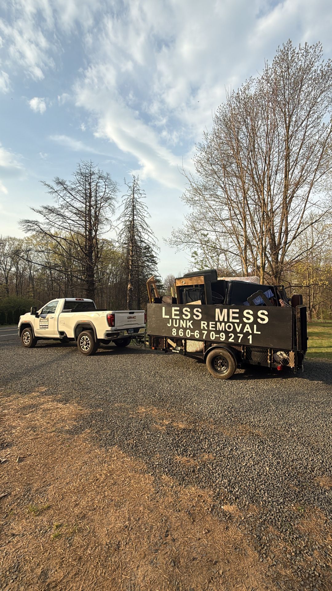 White pickup truck towing a black trailer labeled 
