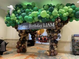 A room decorated with balloons and a sign that says `` happy birthday liam ''.