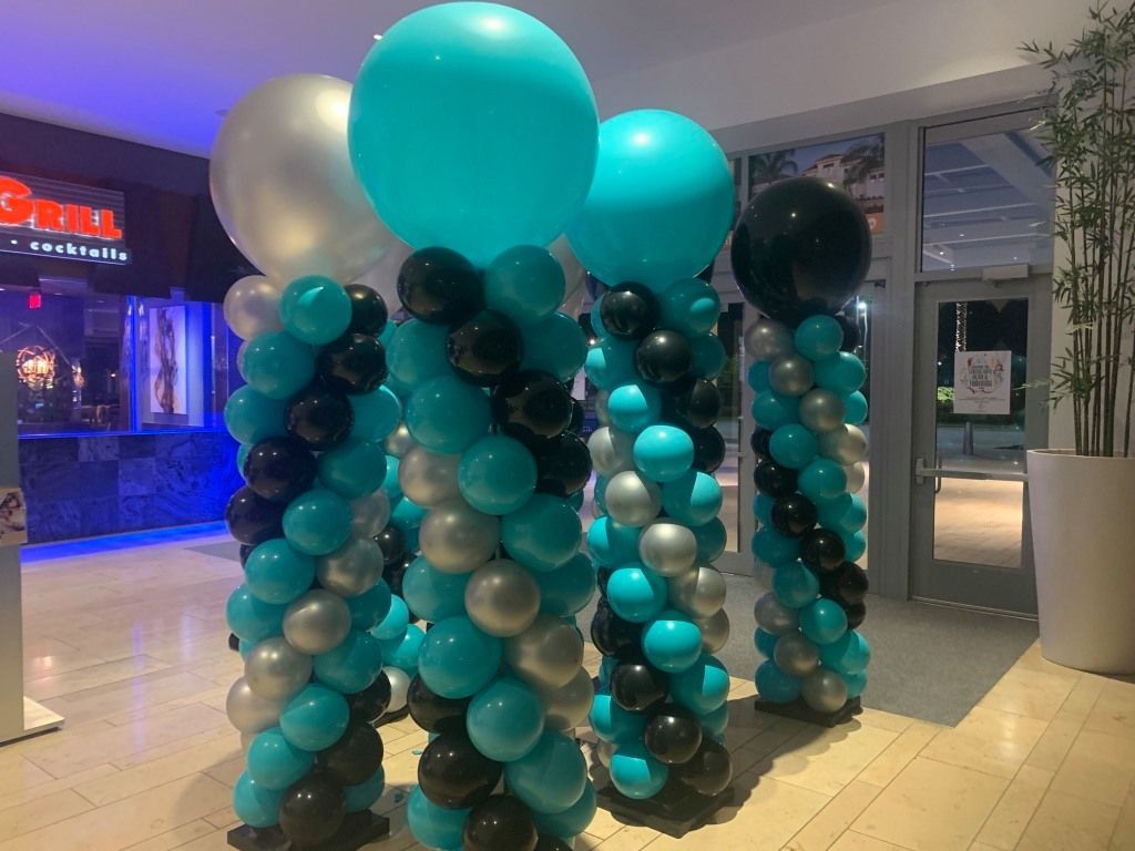 A bunch of balloons are stacked on top of each other in a room.