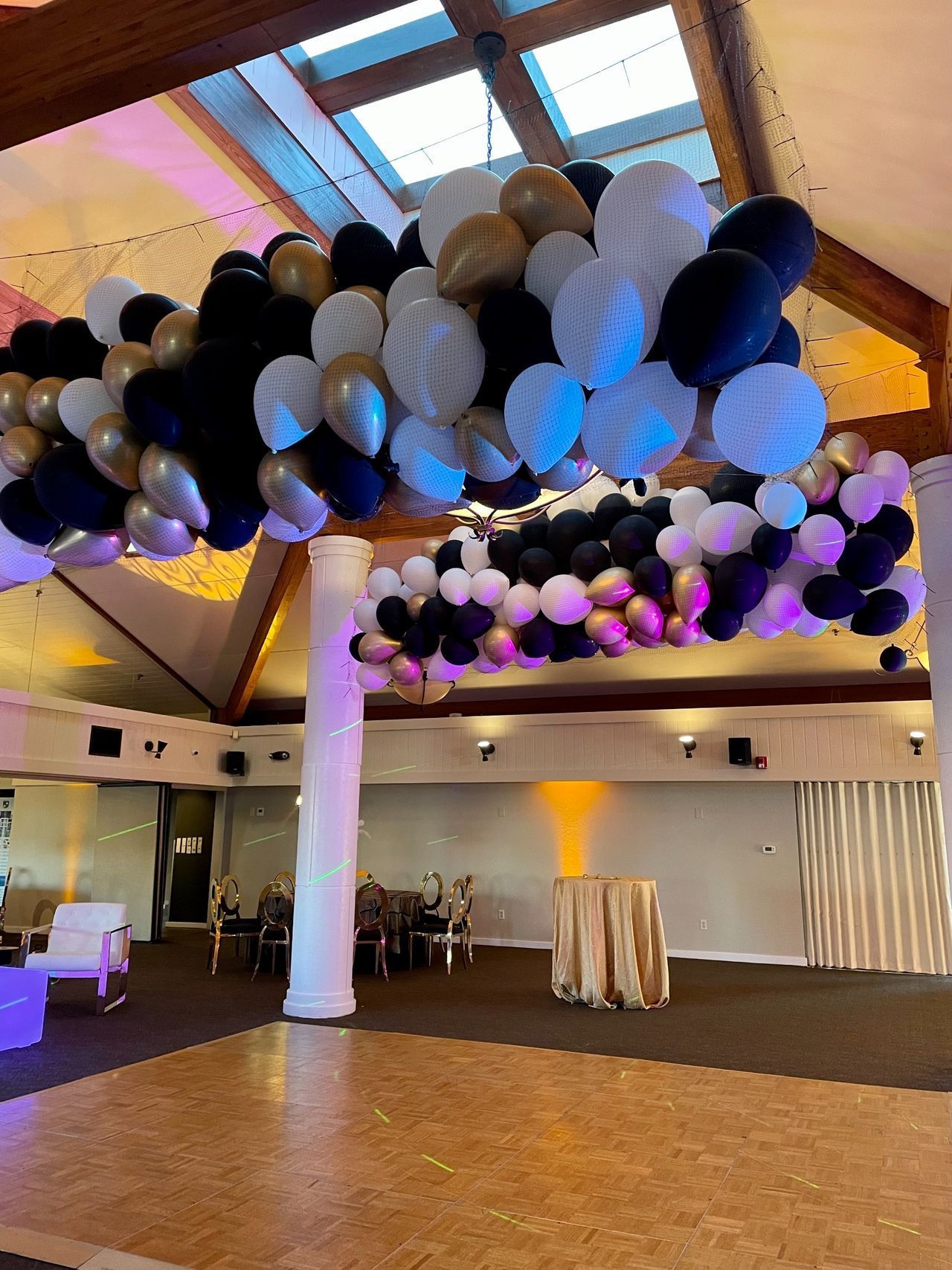 A bunch of balloons are hanging from the ceiling of a room.