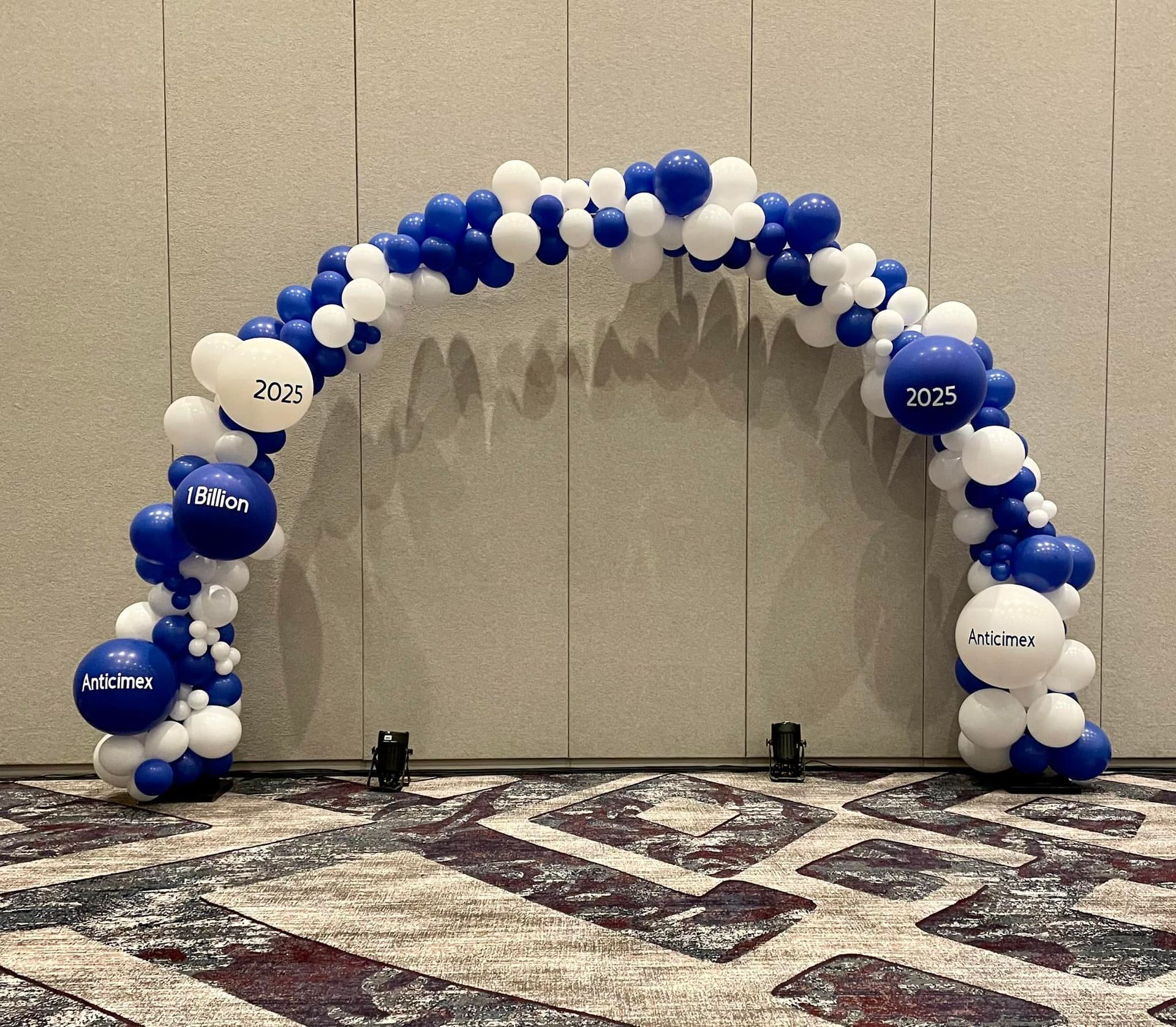 A blue and white balloon arch in a room