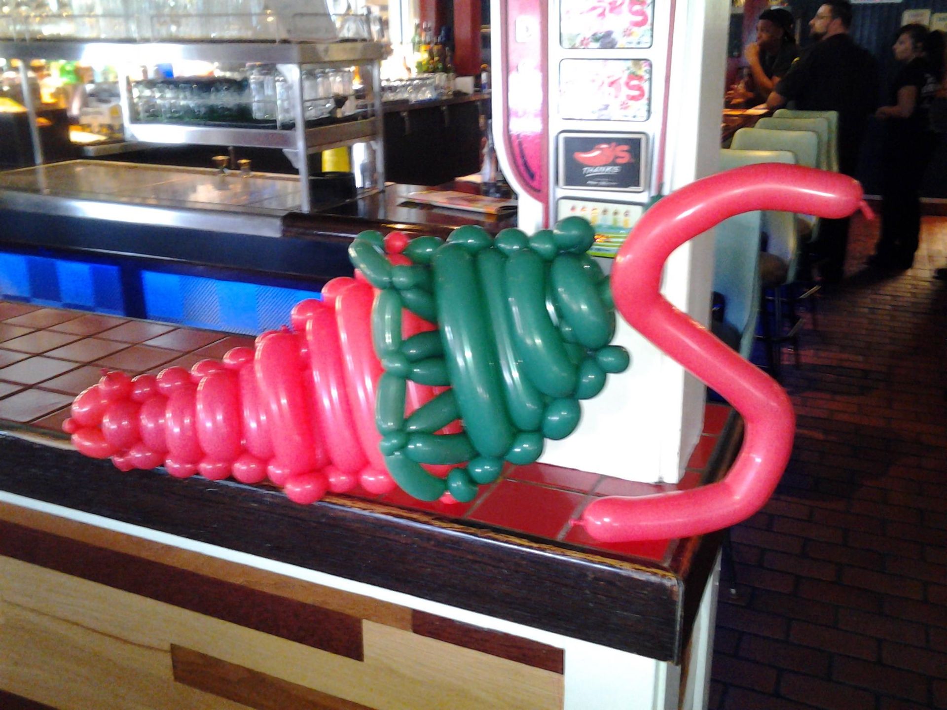 The letter s is made out of red and green balloons