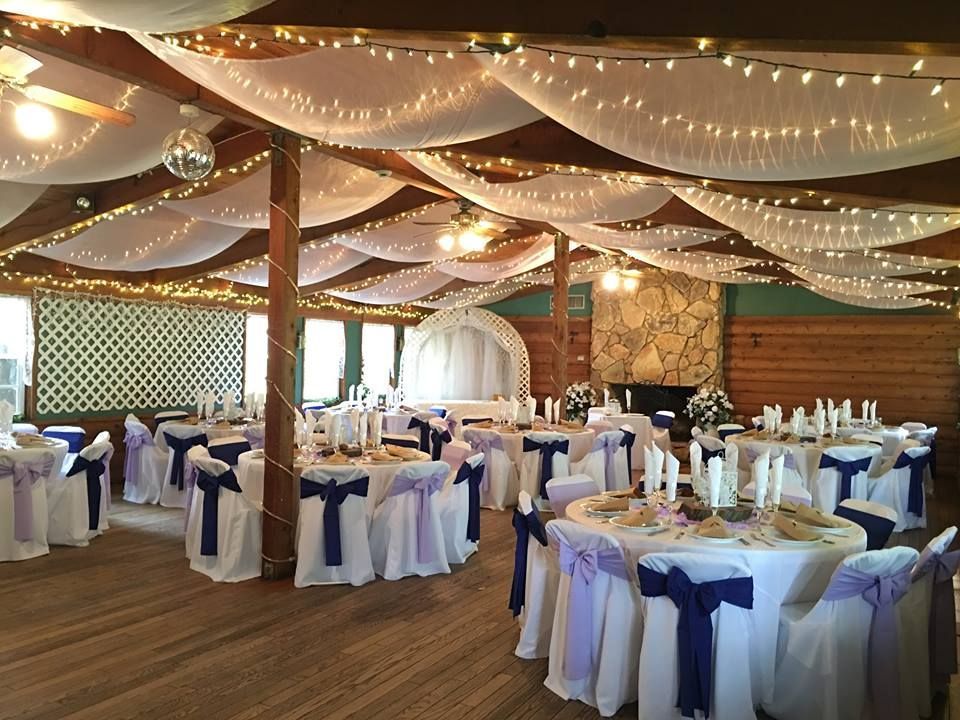 A large room with tables and chairs set up for a wedding reception.