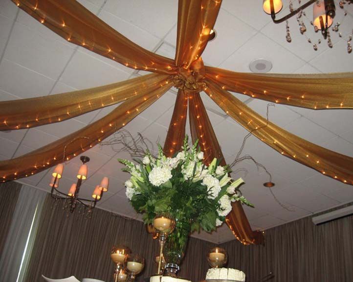 A vase of flowers hanging from the ceiling of a room