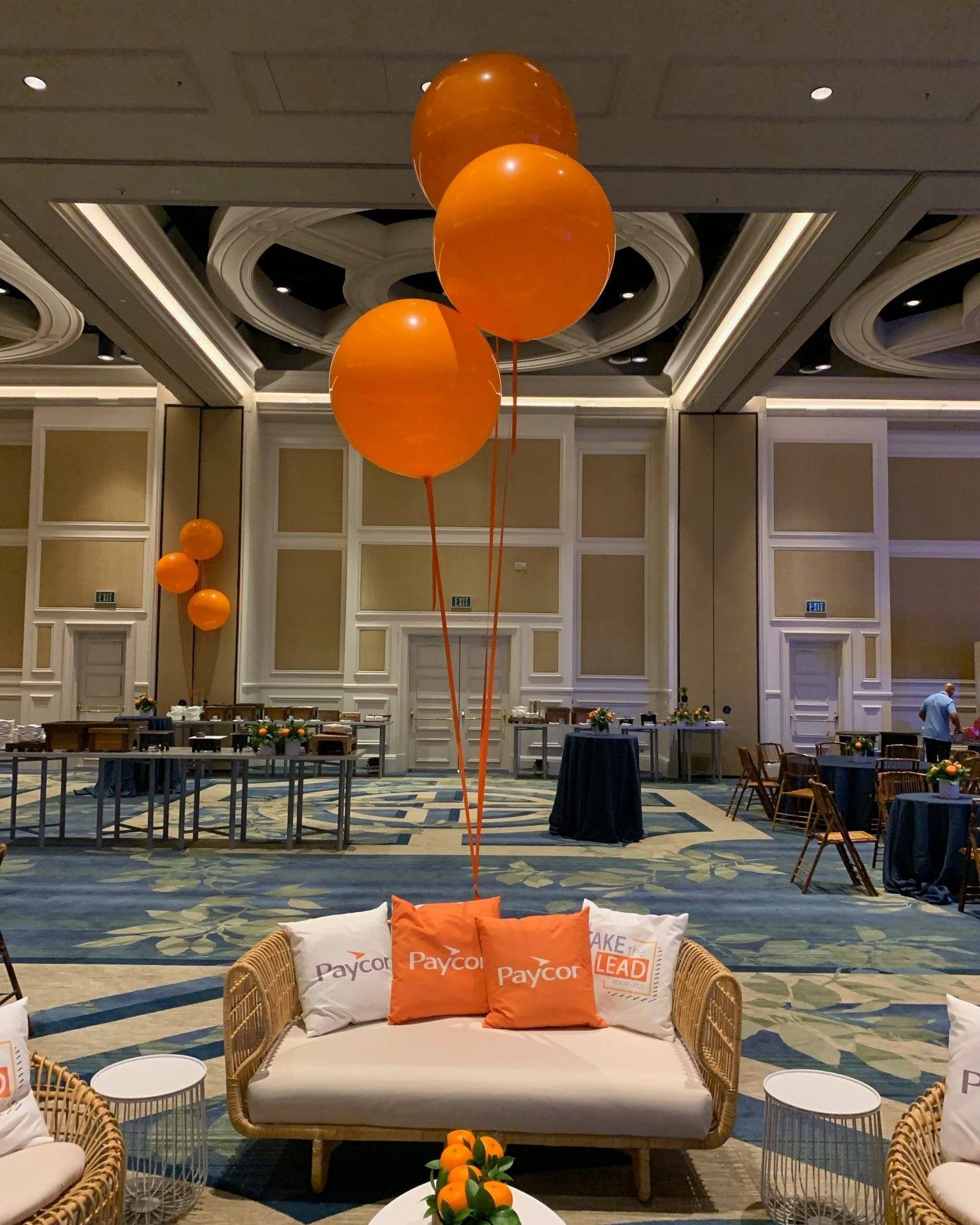 A large room with orange balloons hanging from the ceiling