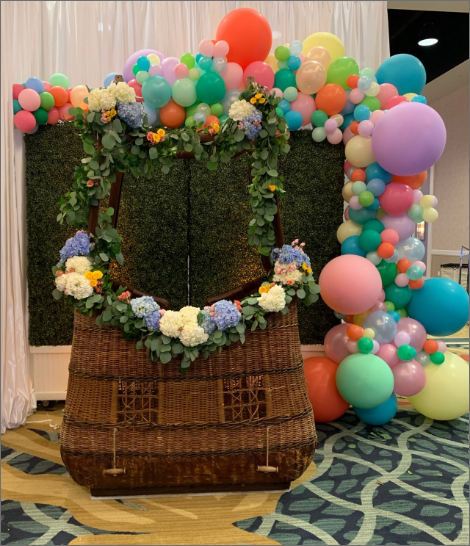 A hot air balloon is decorated with flowers and balloons