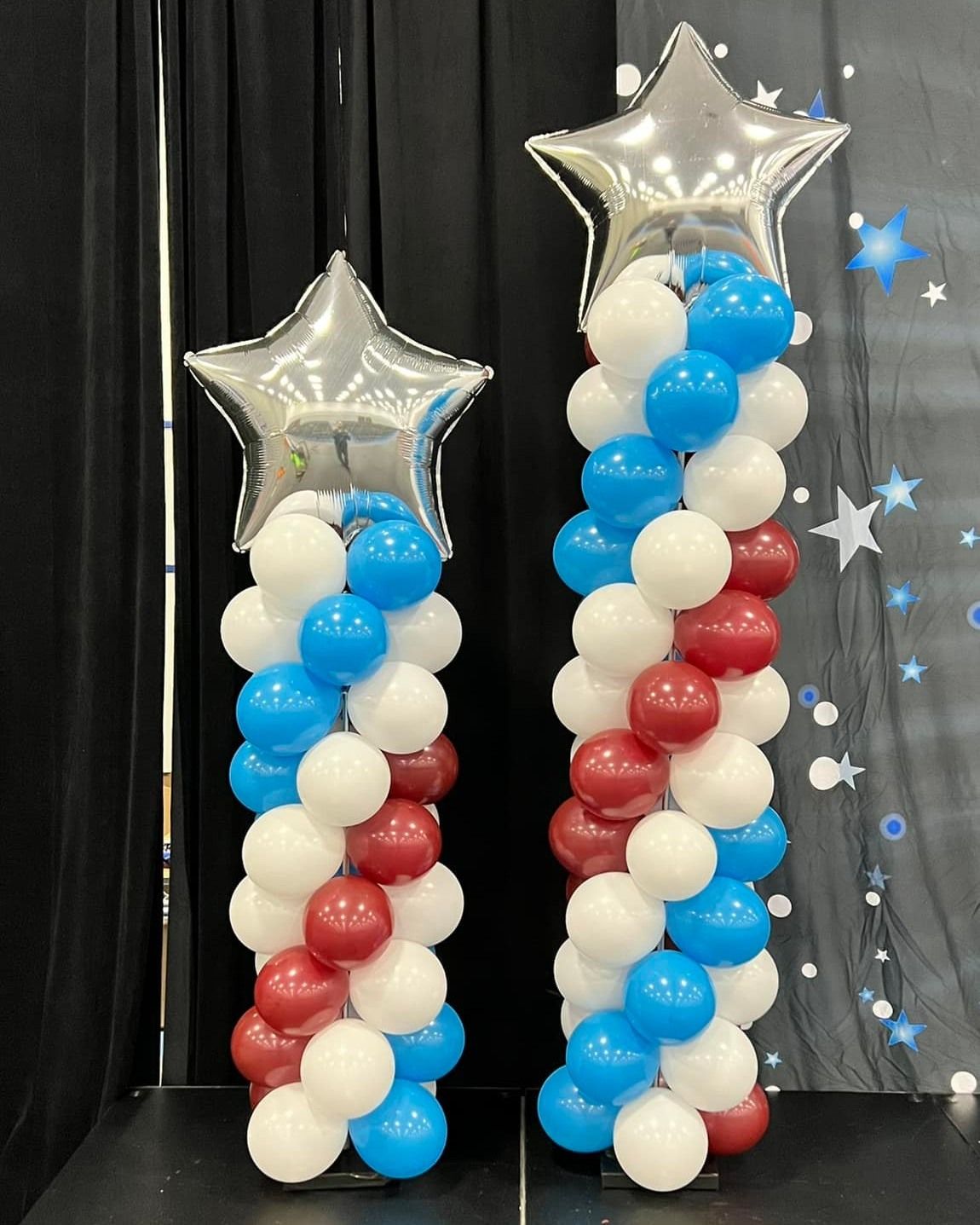 Two columns made of red , white and blue balloons with stars on top.