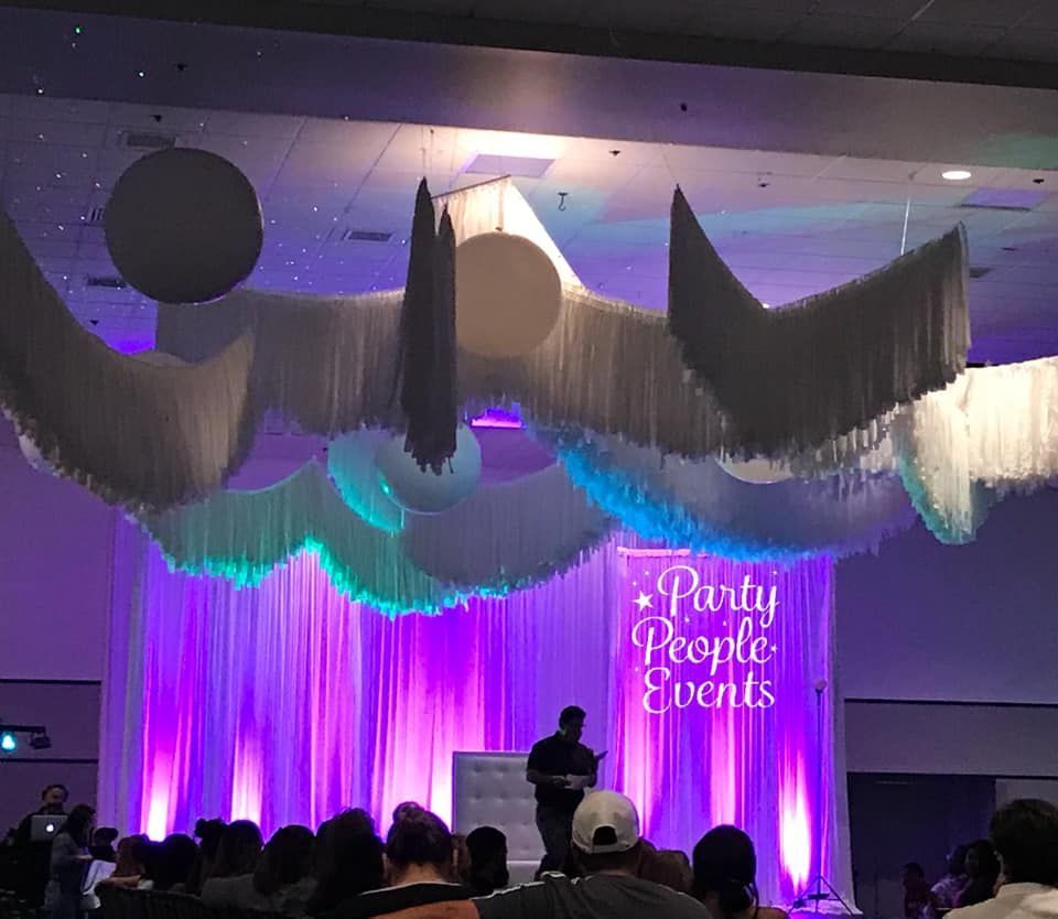 A man is giving a speech in front of a crowd at a party people events event.