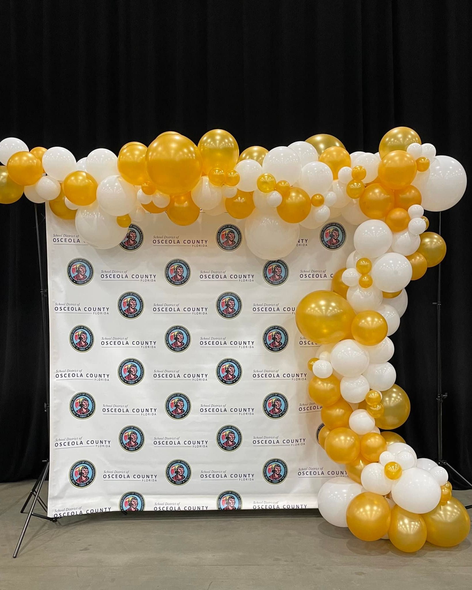 A bunch of yellow and white balloons are hanging from a wall.