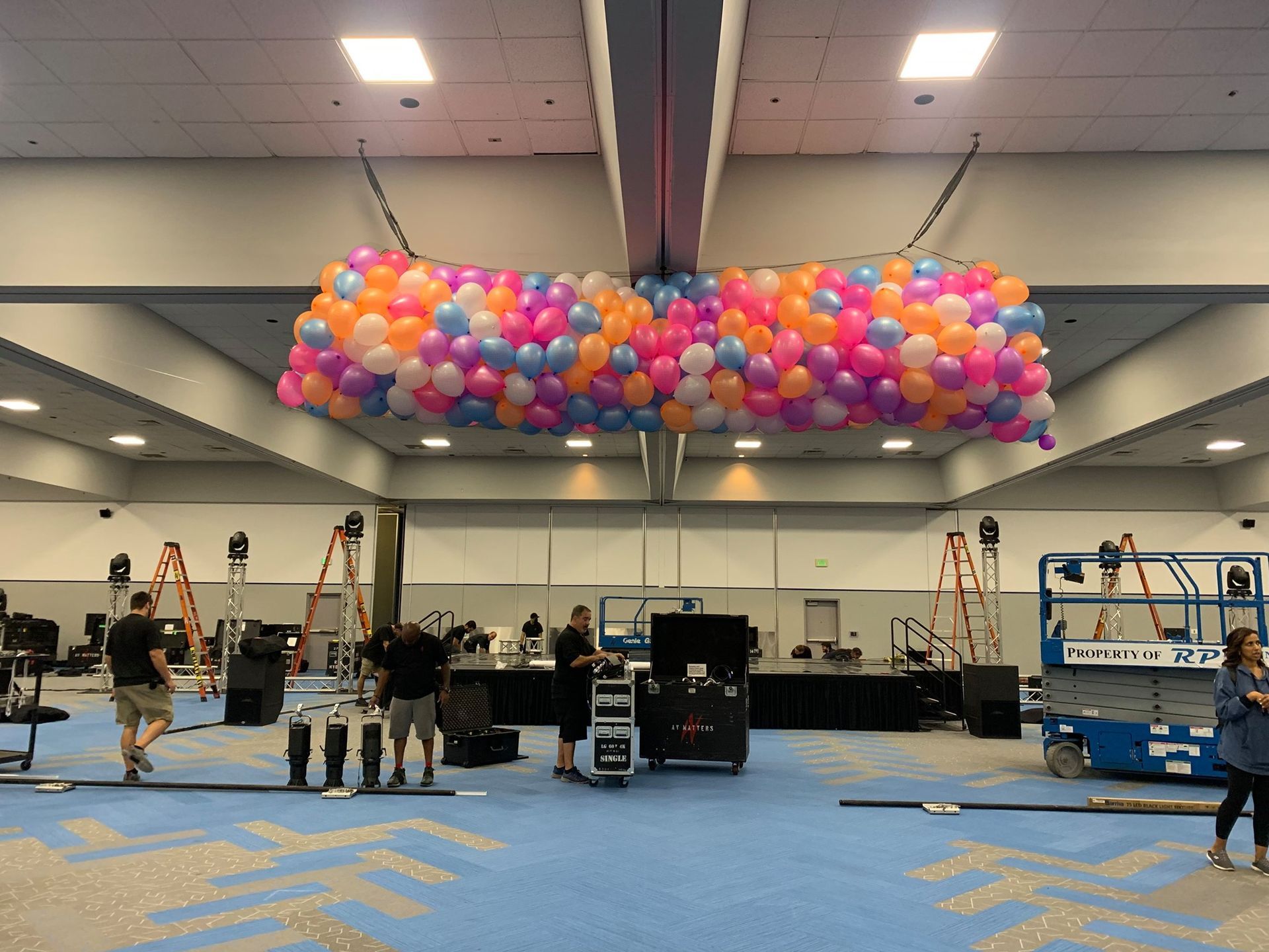 A bunch of balloons are hanging from the ceiling of a room