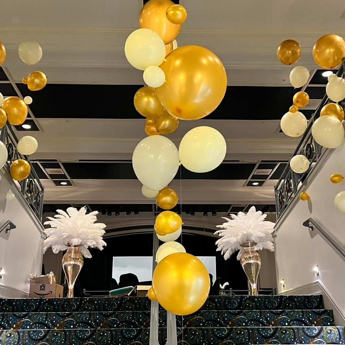 A bunch of balloons are hanging from the ceiling in a room