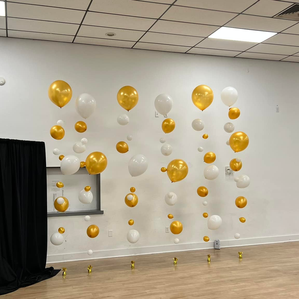 A bunch of balloons are hanging from the ceiling in a room