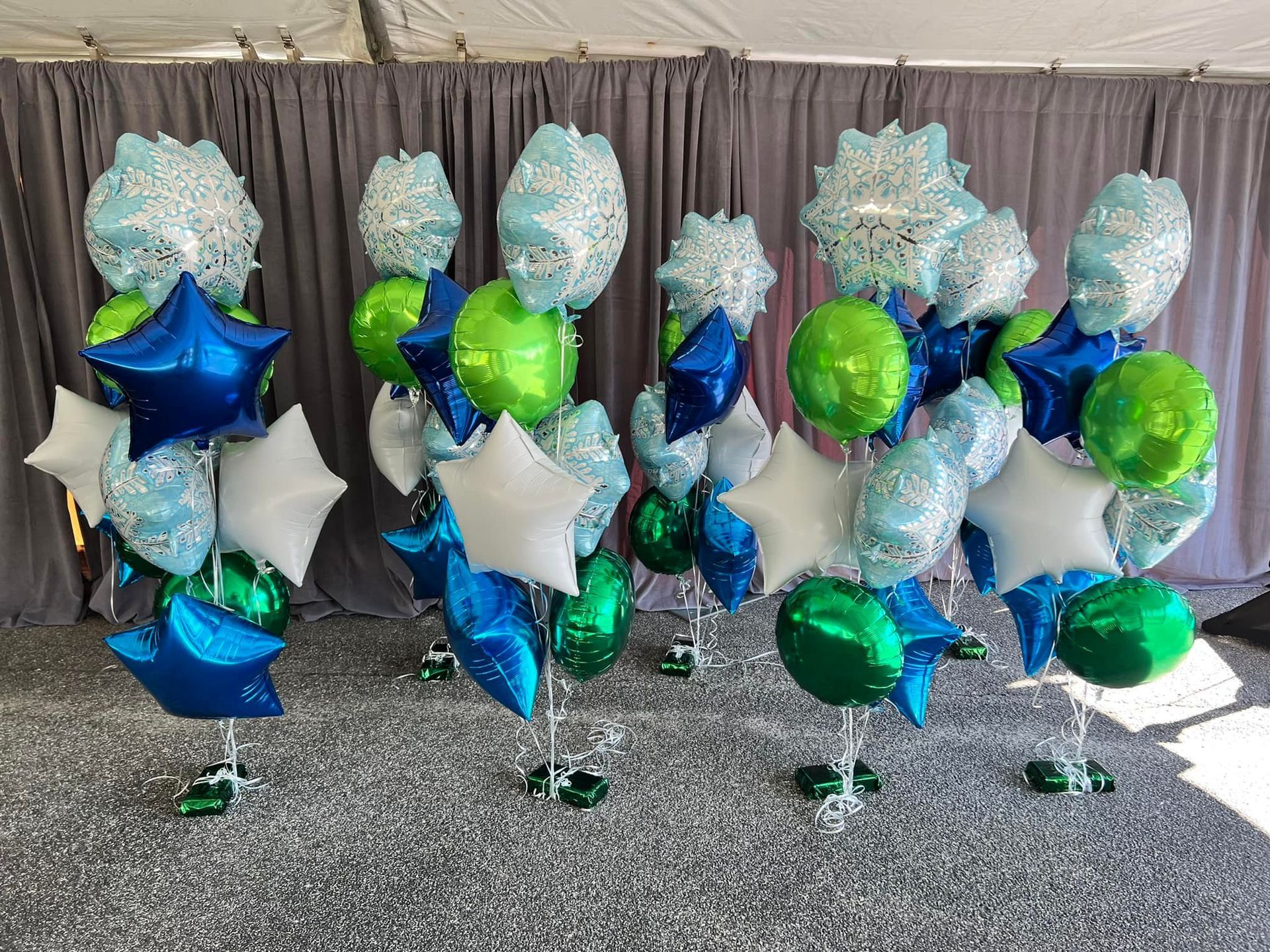 A bunch of blue and green balloons are sitting on a table.