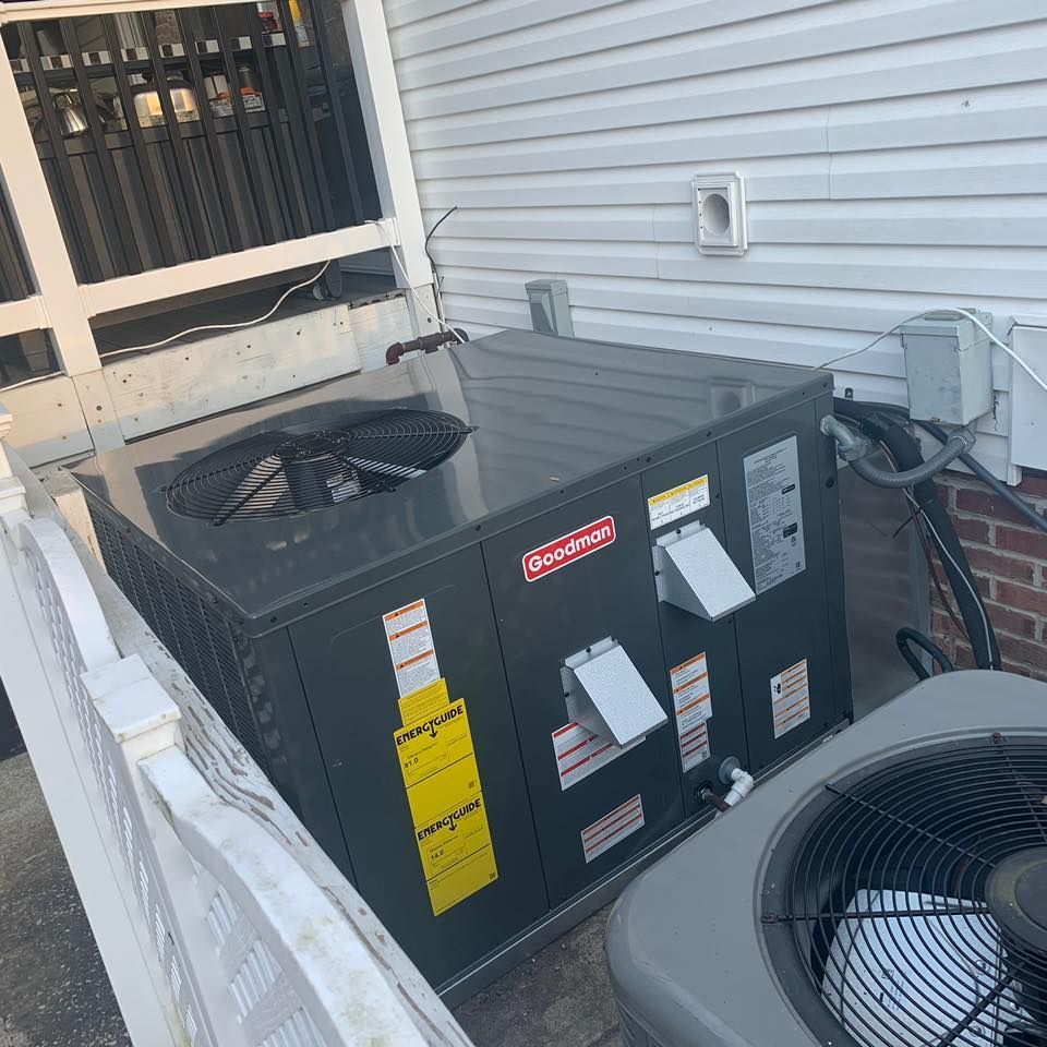 Air Rescue Heating & Cooling | an air conditioner is sitting on the side of a house next to a fence.