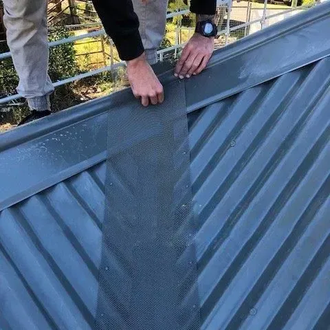 cut gutter guard along metal roof valley ridge