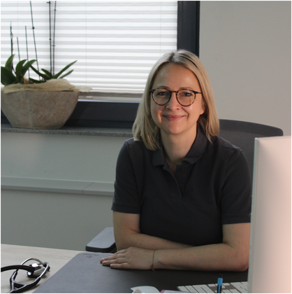 Frau Dr. med. Heimer sitzend an Ihrem Arbeitsplatz.