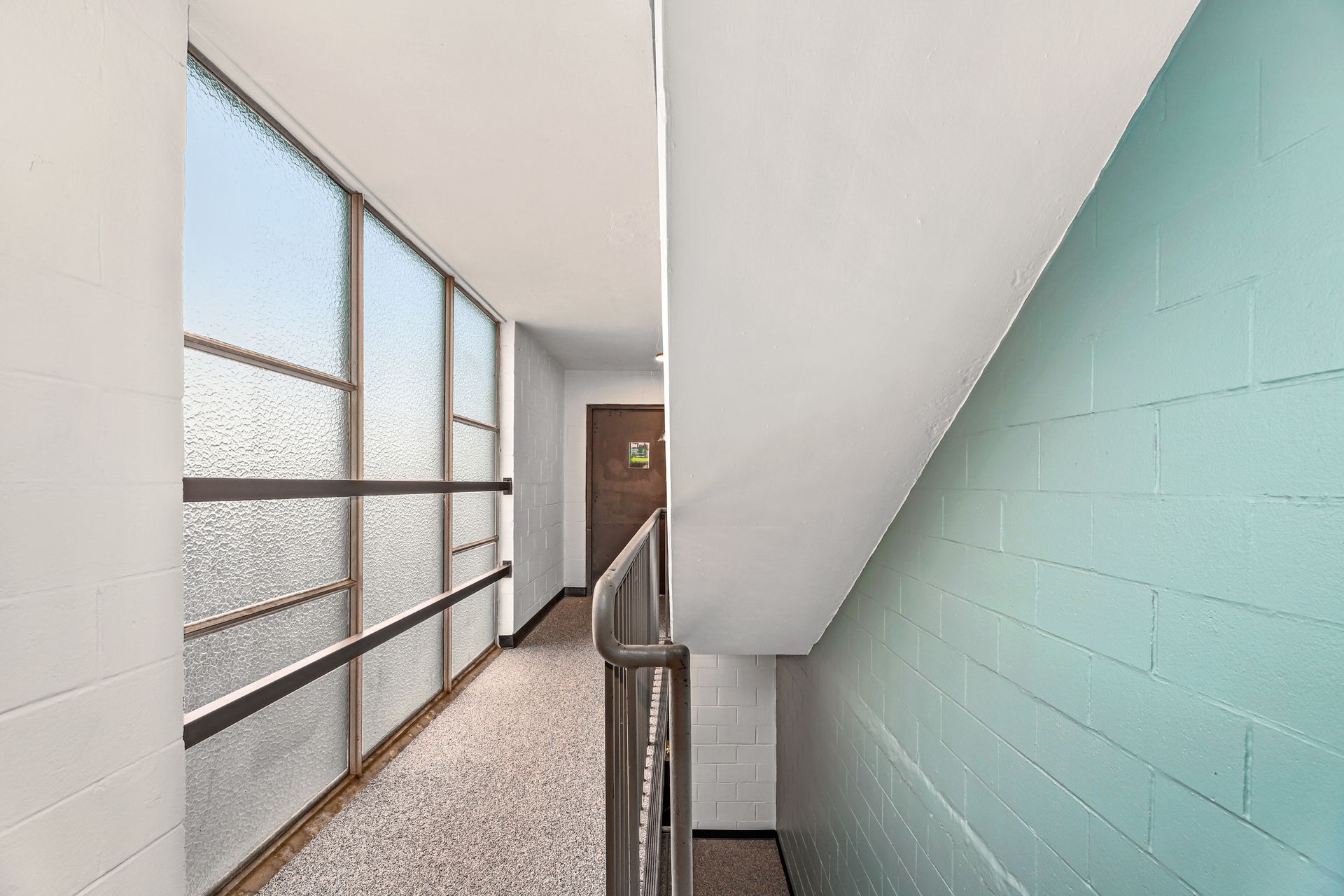 A hallway with stairs leading up to the second floor of a building.