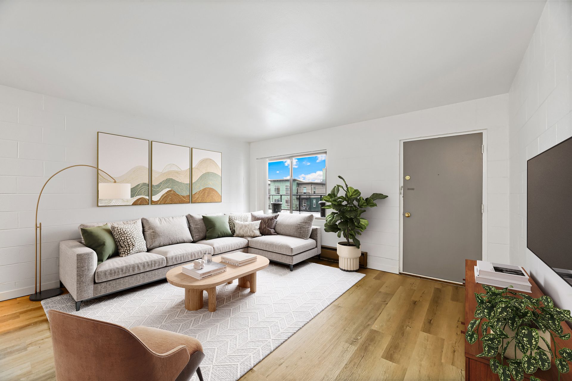 A living room with a couch , chair , coffee table and television.