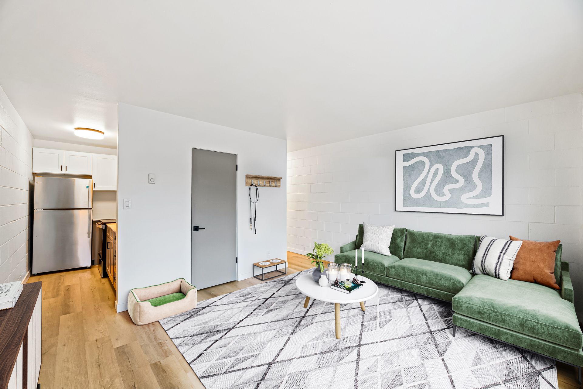 A living room with a green couch and a white coffee table.