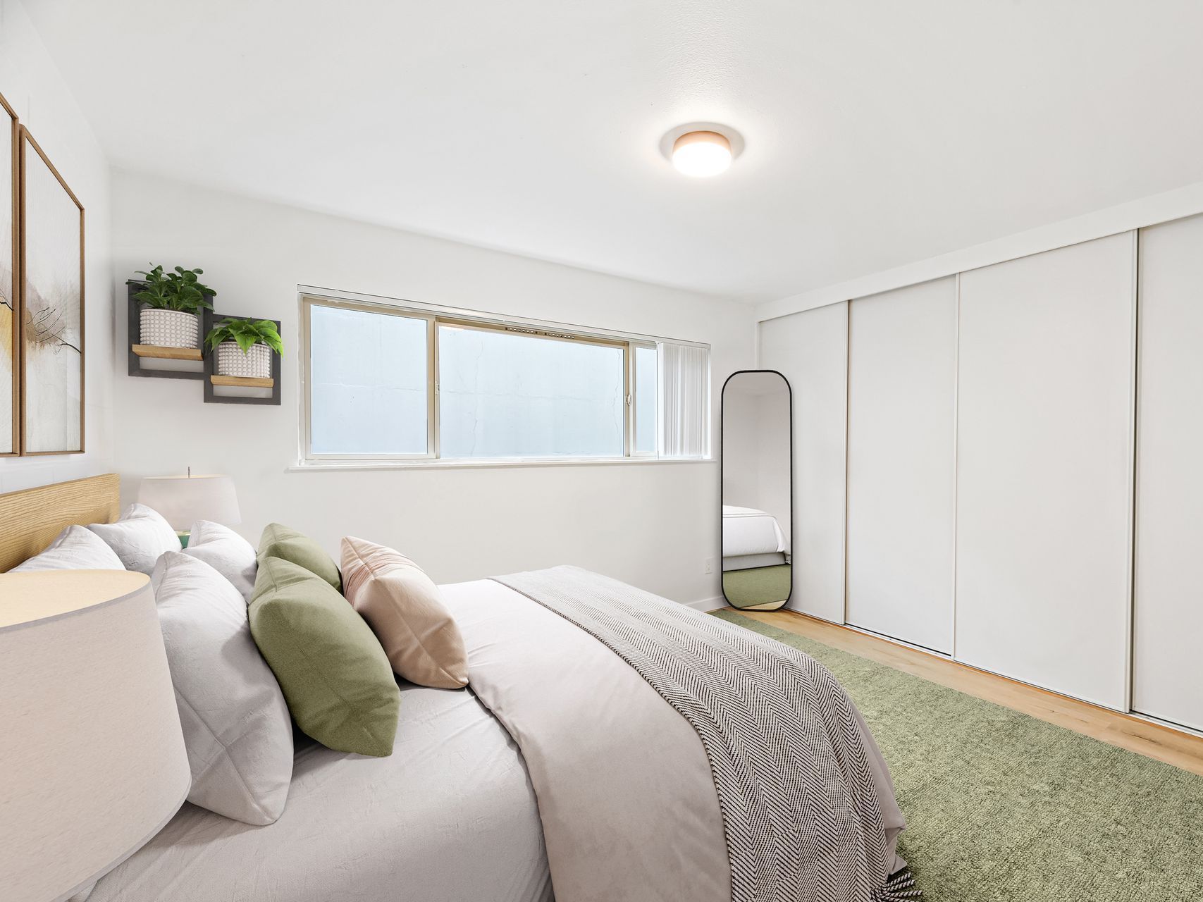 A bedroom with a bed , mirror and sliding glass doors.