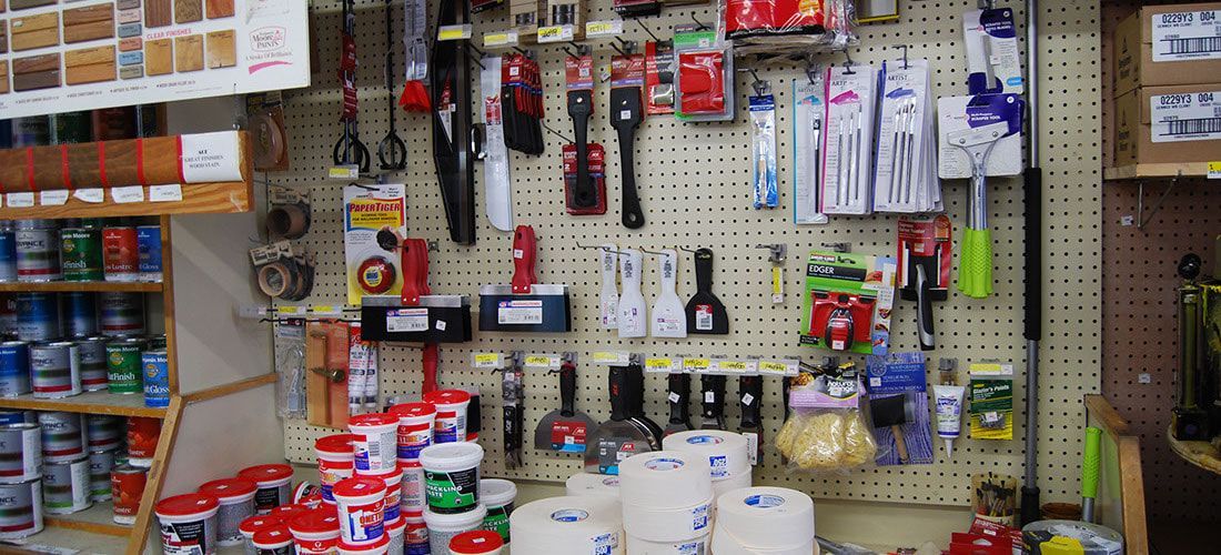 A bunch of tools are hanging on a wall in a store.