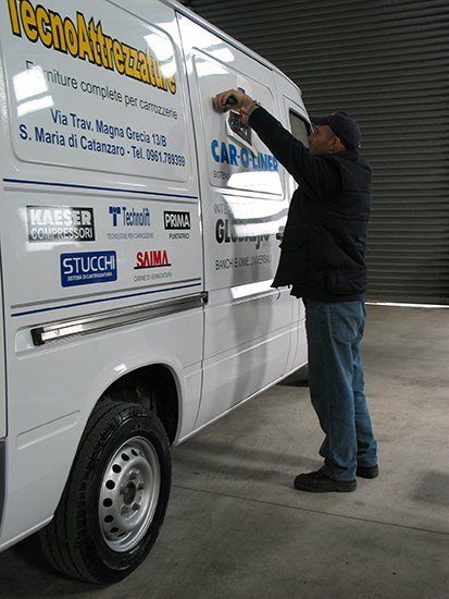 Uomo che applica un logo all'esterno di un camion