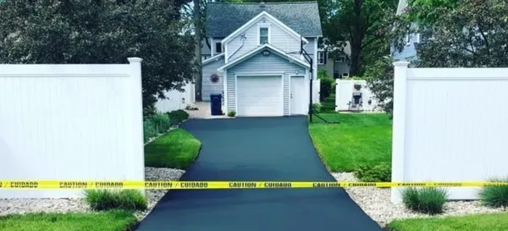 A driveway leading to a house with a yellow tape covering it.