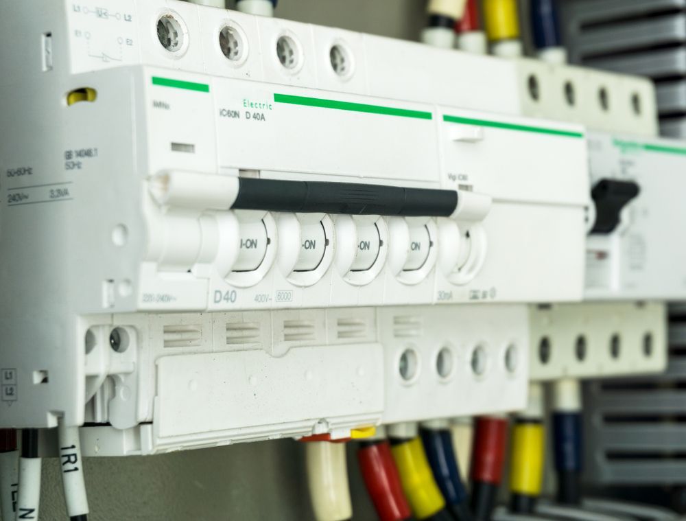 Electrical Circuit Breakers With White Panels, Wires, and on/off Toggles — Pure Plumbing & Electrical in Dubbo, NSW
