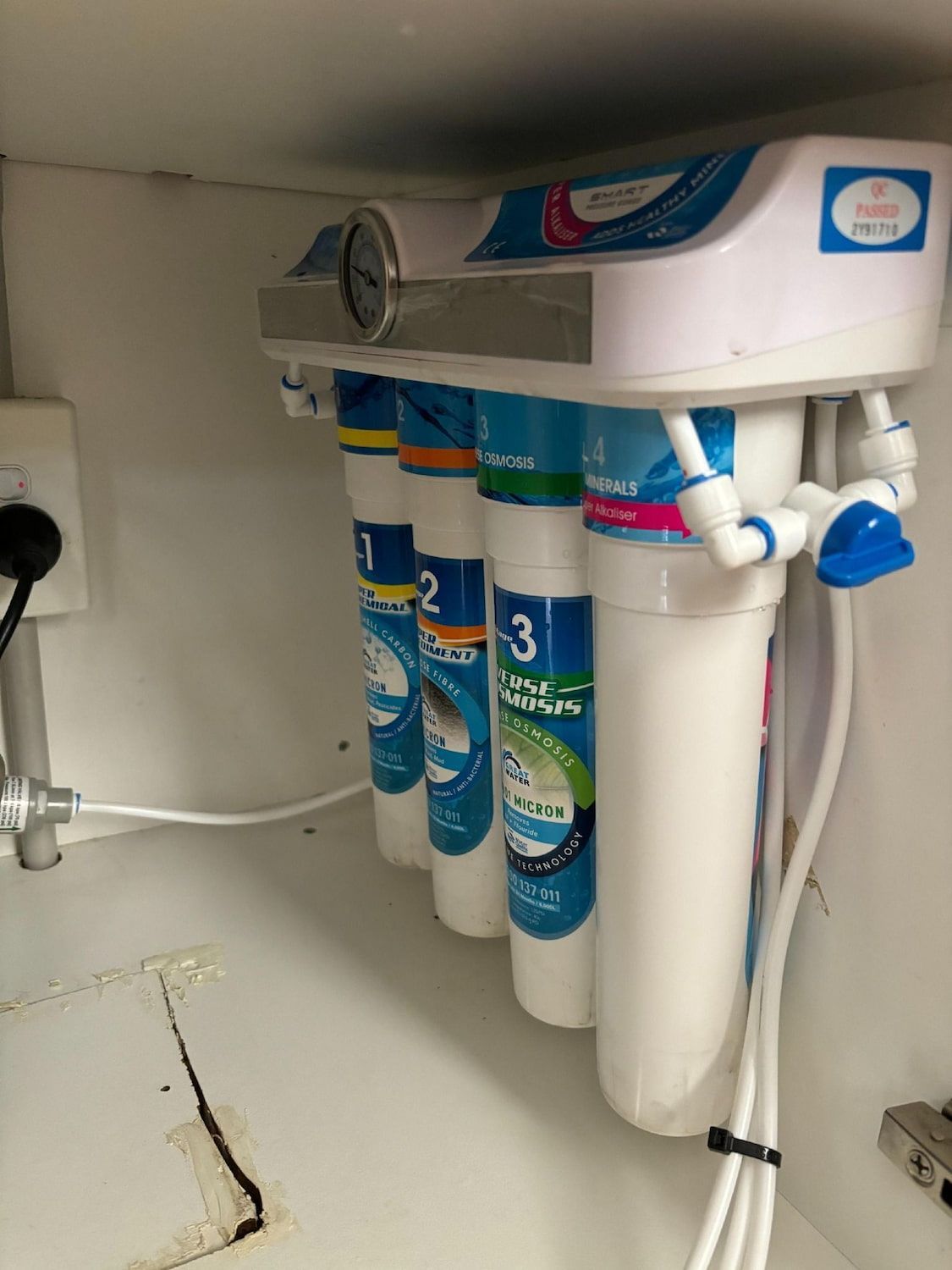 Water Filter System Under a Sink With Blue, Yellow, and White Filters — Pure Plumbing & Electrical in Orange, NSW