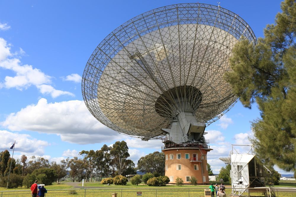 Large Radio Telescope Dish Against a Blue Sky, in a Grassy Field — Pure Plumbing & Electrical in Parkes, NSW