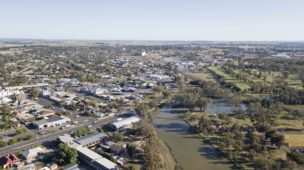 Aerial View of a Town With a River and Scattered Buildings Under a Clear Sky — Pure Plumbing & Electrical in Forbes, NSW