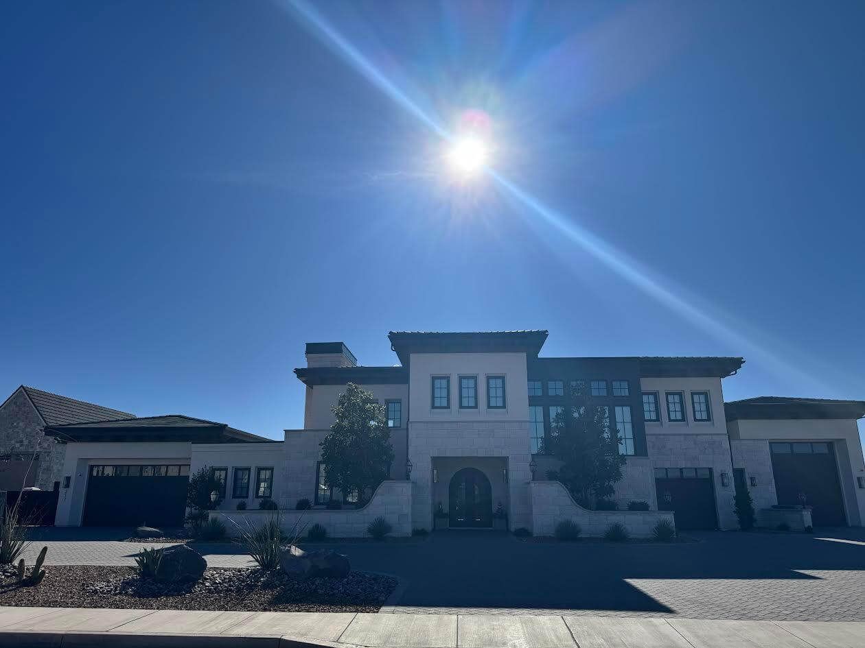 A large white house with a blue sky in the background.