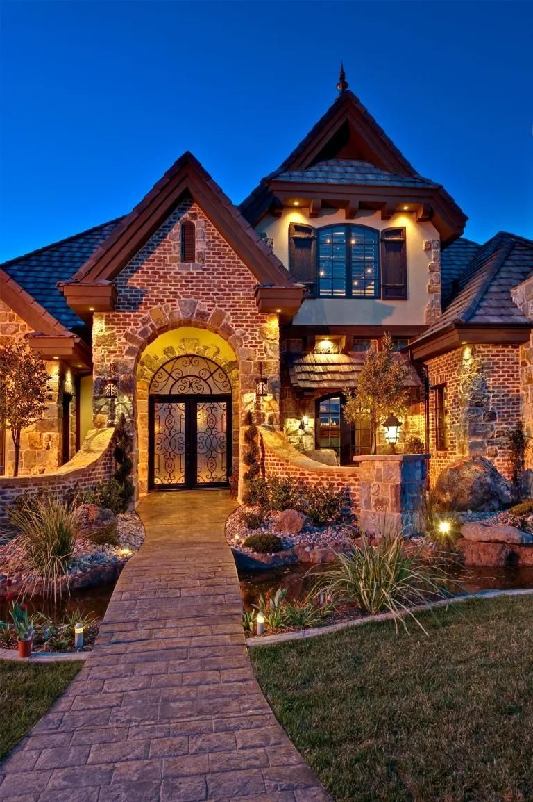 A large brick house with a walkway leading to it at night
