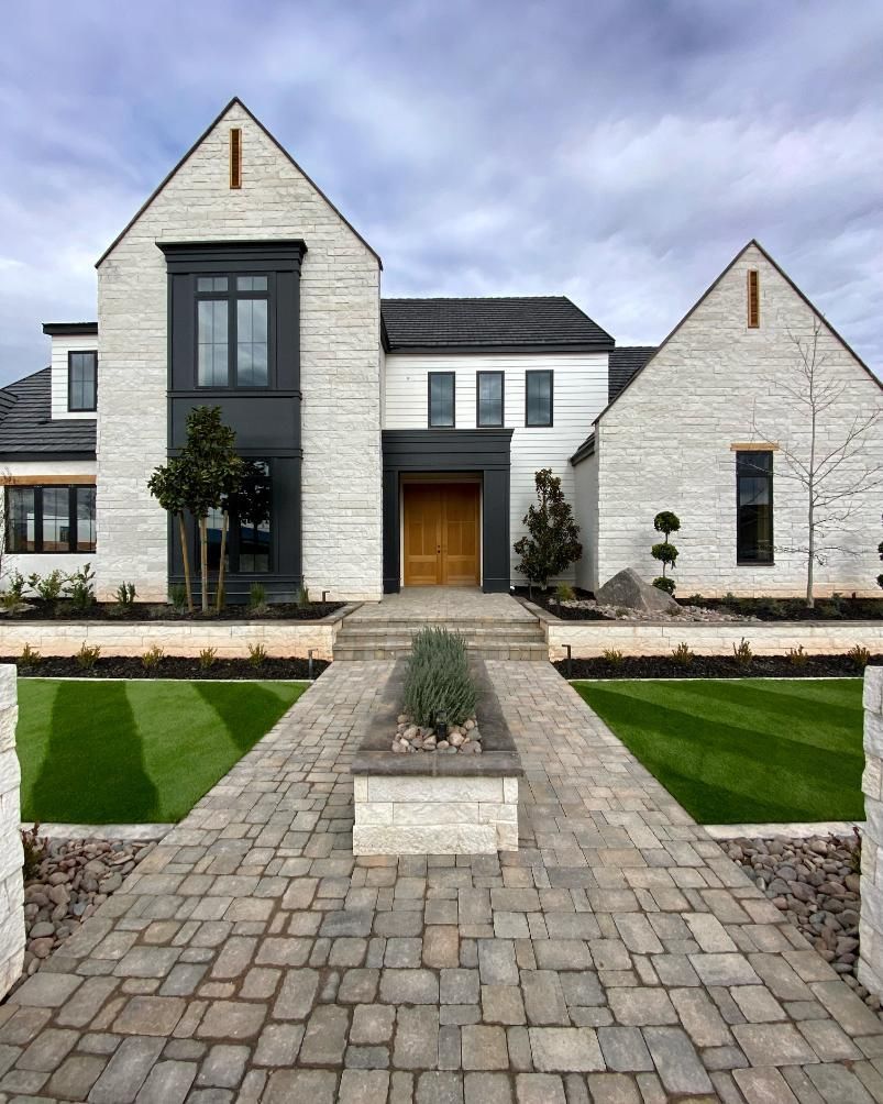 A large white house with a brick walkway leading to it