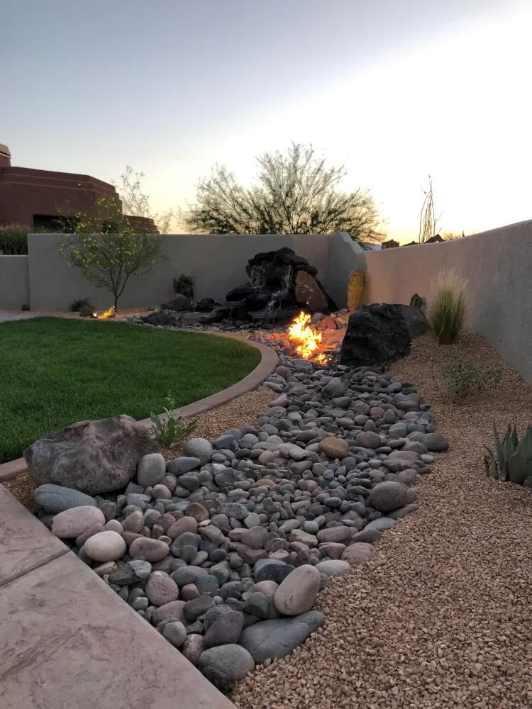 A rock garden with a fire pit in the middle of it