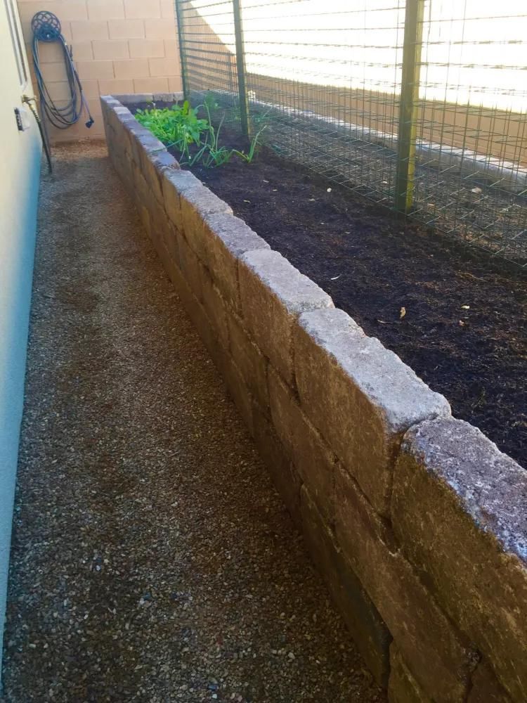 A brick wall with a garden in the middle of it